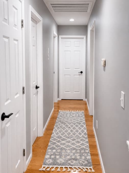 Finished hallway with white doors and black hardware