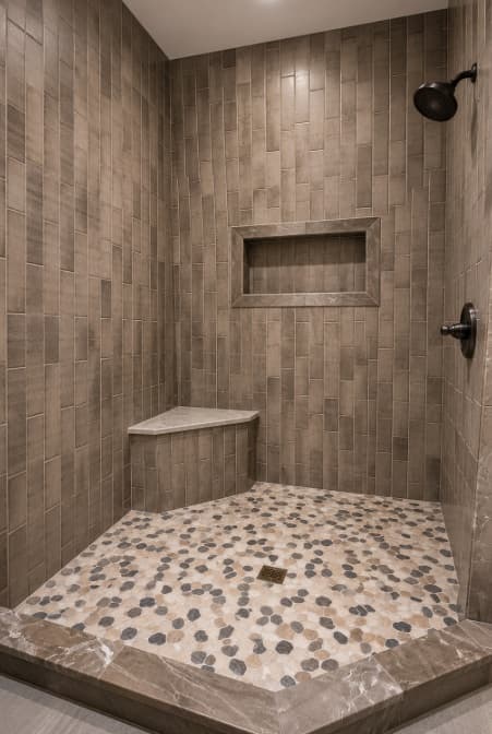 Finished warm brown tile shower with pebble floor